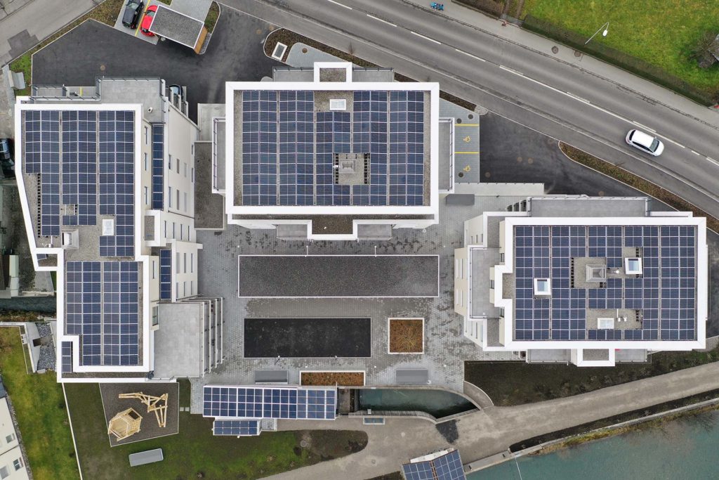 top down view of three buildings with photovoltaic panels covering all three roofs